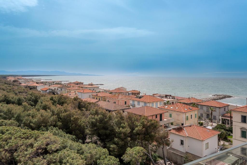 un groupe de maisons sur une colline à côté de l'océan dans l'établissement Hotel Tornese - Rooftop Sea View, à Marina di Cecina