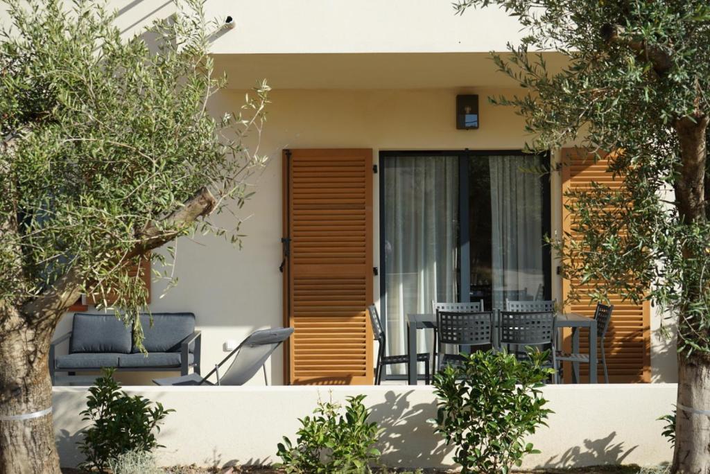 a house with a patio with chairs and trees at Résidence CATALINA in Saint-Florent