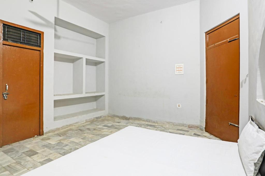 una camera con un letto e due porte in legno di Super OYO OYO Double Heart a Bhādra