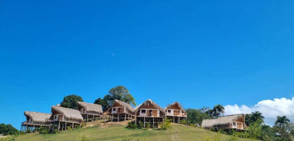 a group of cottages on a hill at Margarita Ecovillage in Miches