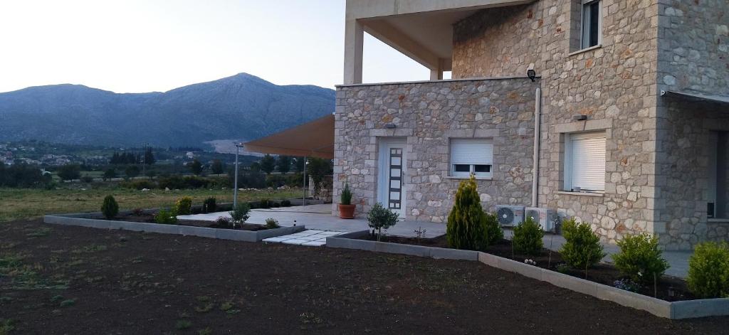 a stone house with plants in front of it at Smailis apartment 2 in Lygourio