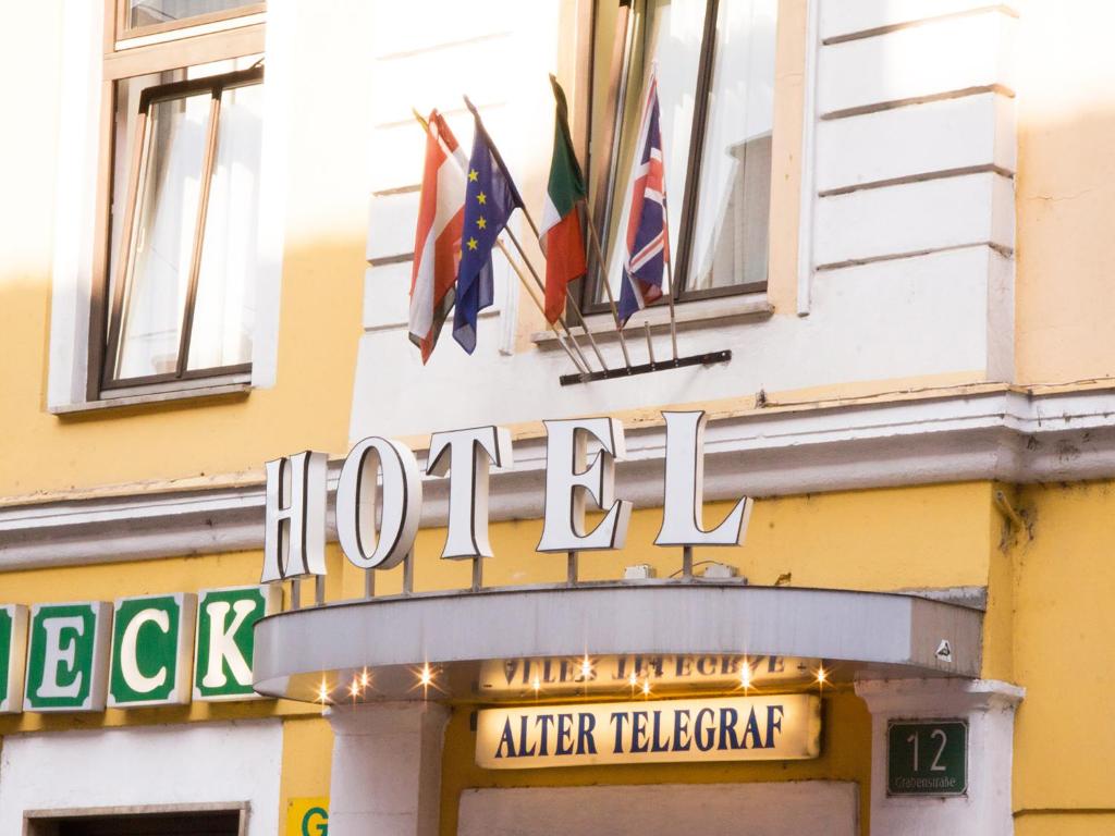 a hotel sign on the side of a building with flags at Hotel Alter Telegraf in Graz