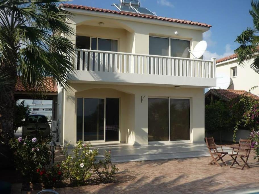een huis met 2 stoelen en een balkon bij Budget Escape to the seaside in Larnaka