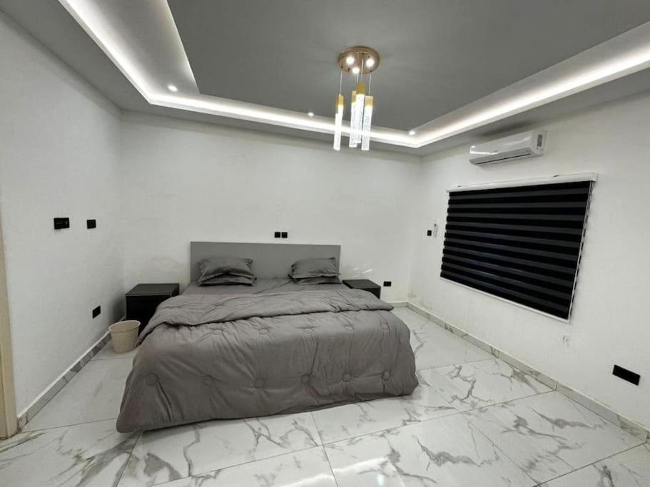 a bedroom with a bed in a white room at Fully Furnished 1 Bedroom House in Accra