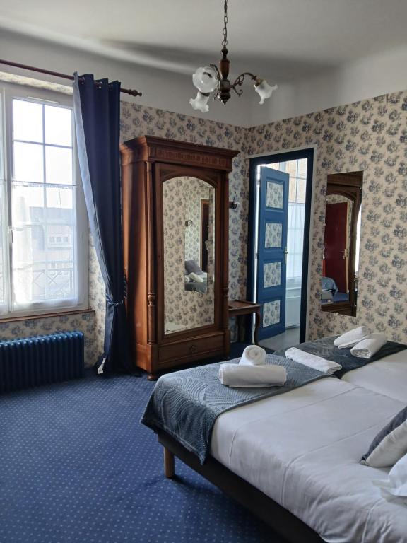 a bedroom with two beds and a mirror at Hotel La Granitiere in Saint-Vaast-la-Hougue