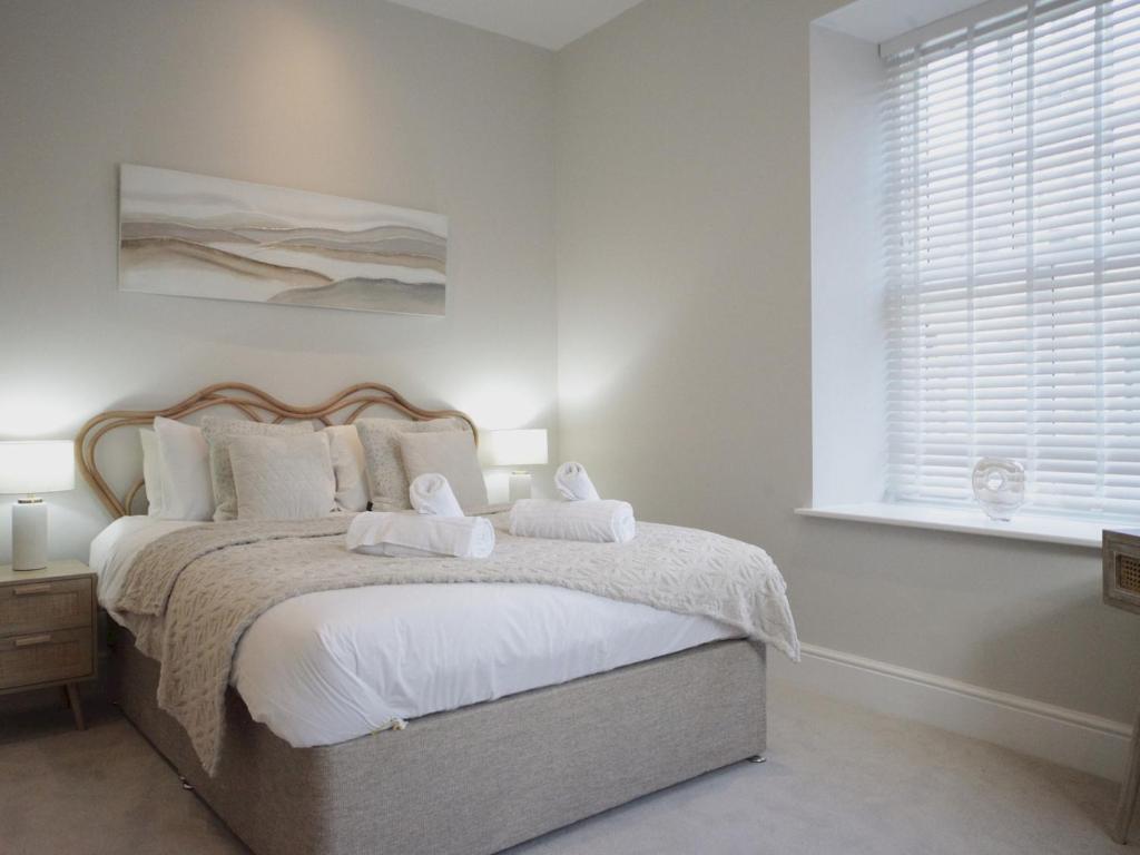 1 dormitorio con 1 cama con 2 toallas en Apartment 6 Old Conservative Club in Historic Town Pass the Keys en Caernarfon