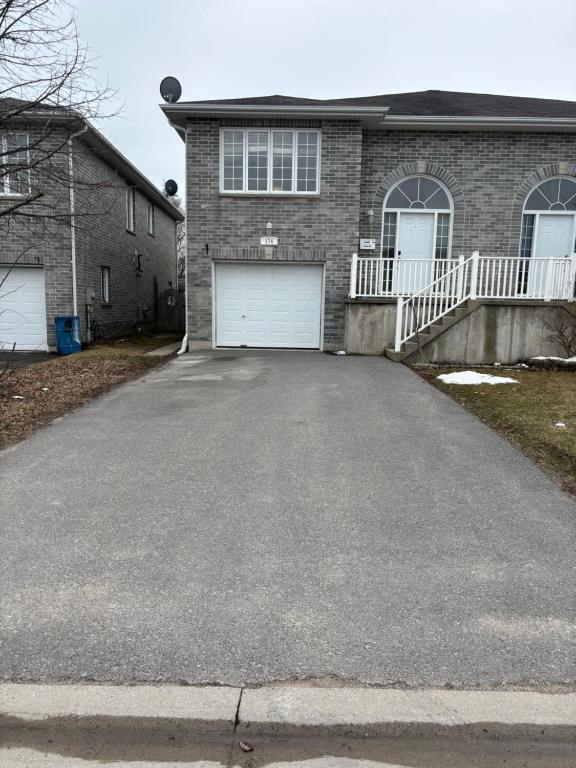 a driveway in front of a brick house at Comfortable apartment in Kingston
