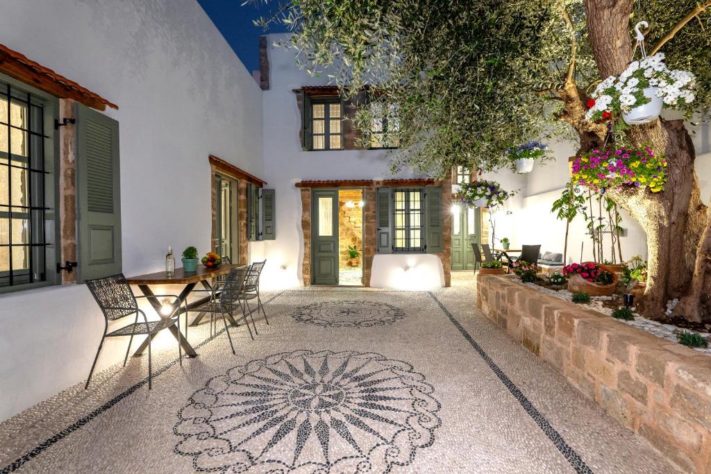 une cour avec une table et des chaises et un bâtiment dans l'établissement Villa del Capo Suites, à Rhodes