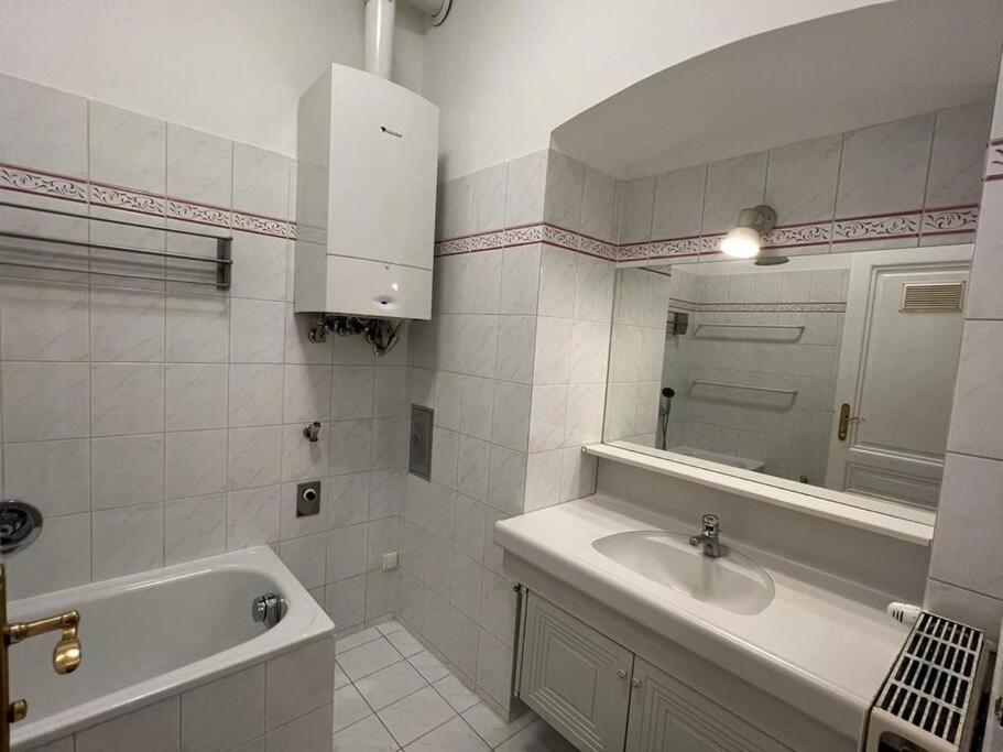 een badkamer met een wastafel, een bad en een spiegel bij 90 m2 Spacious Apartment - 15 min to Center in Wenen