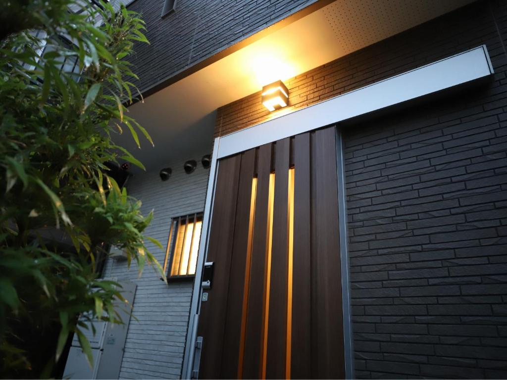 uma porta da frente de uma casa com uma luz sobre ela em 一棟貸切り宿 GuestHouse 嵯峨嵐山 em Quioto
