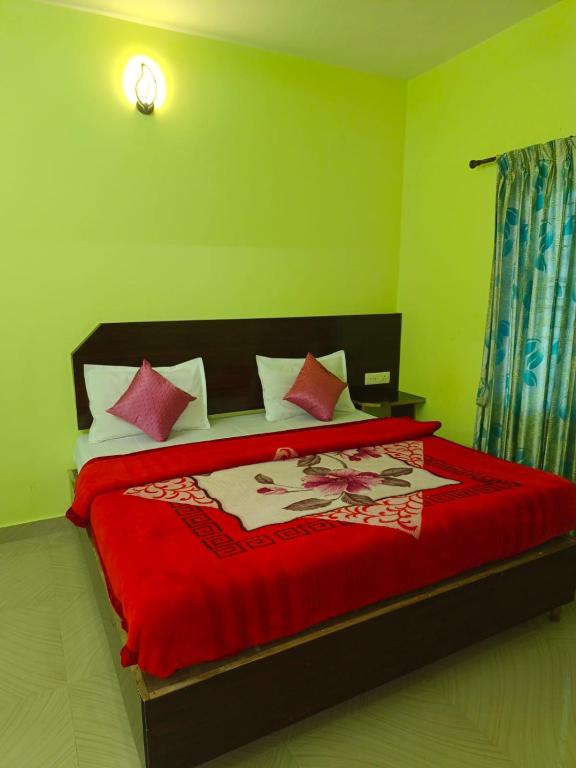 a bedroom with a large bed with a red blanket at Pavithra cottage munnar in Munnar