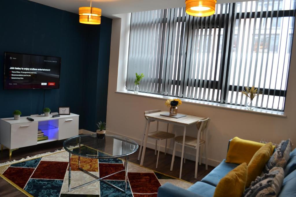 ein Wohnzimmer mit einem Sofa und einem Tisch in der Unterkunft Stylish One Bedroom City Centre Apartment with Free Parking in Birmingham