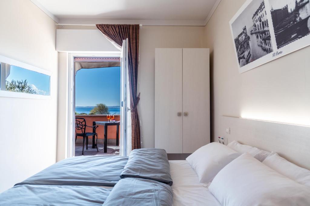 a bedroom with a bed and a view of the ocean at Albergo Cristina in Lazise