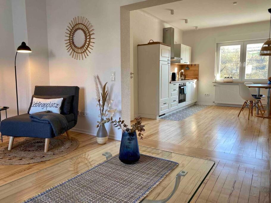 a living room with a chair and a kitchen at Ferienwohnung Lieblingsplatz in Tholey