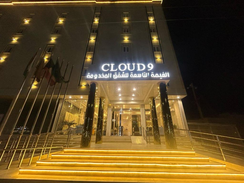 un edificio con escaleras delante de él por la noche en فندق الغيمة التاسعة en Hafr Al Batin