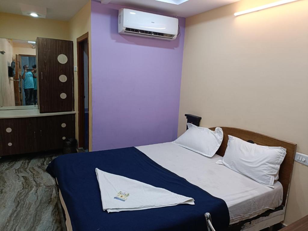 a bedroom with a bed and a tv on a wall at Hotel Dakshin Sea Paradise in Visakhapatnam