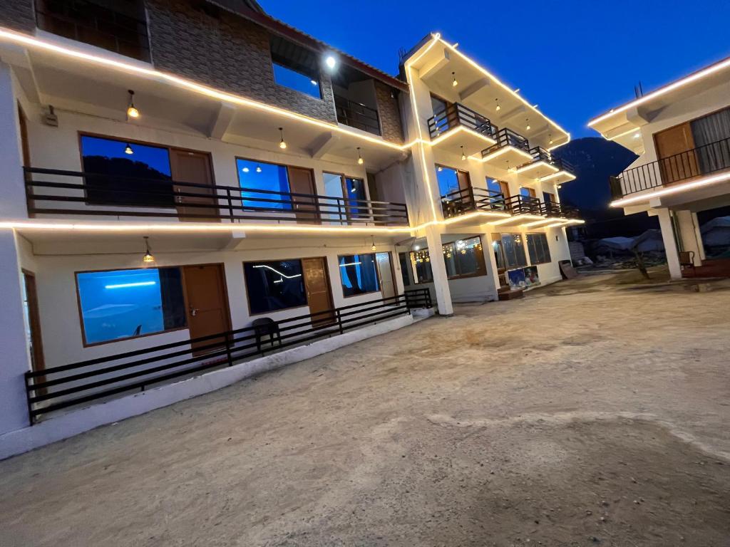 ein großes Apartmenthaus mit einem Parkplatz in der Nacht in der Unterkunft Solank Hotel & Cafe in Amritsar