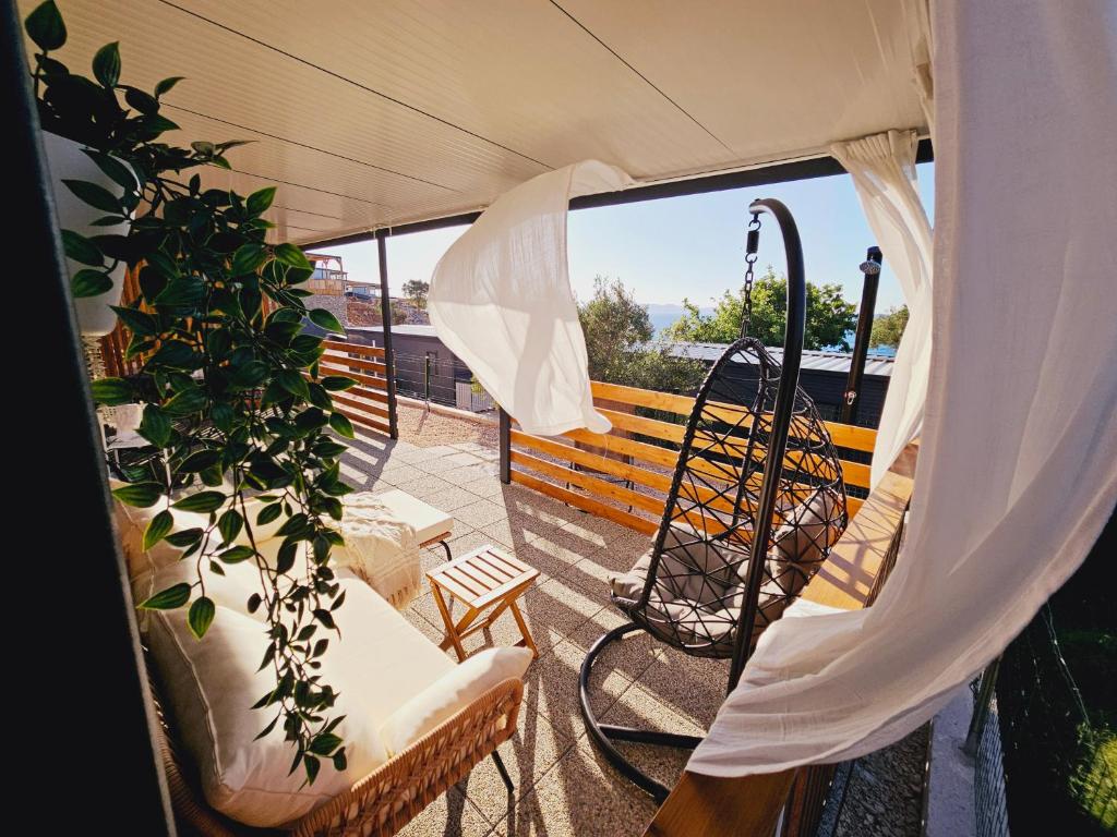 a balcony with a bench and a plant at Mobile home Jadre I in Pakoštane