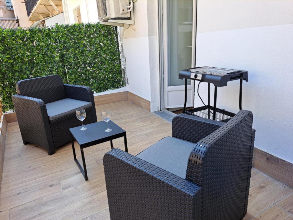une terrasse avec 2 chaises et une table avec des verres dans l'établissement Studio coin nuit terrasse à 5 minutes de la plage N1, à Saint-Laurent-du-Var