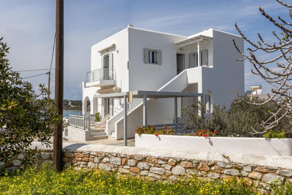 a white villa with a view of the ocean at Lydia's East Apartment in Aliki