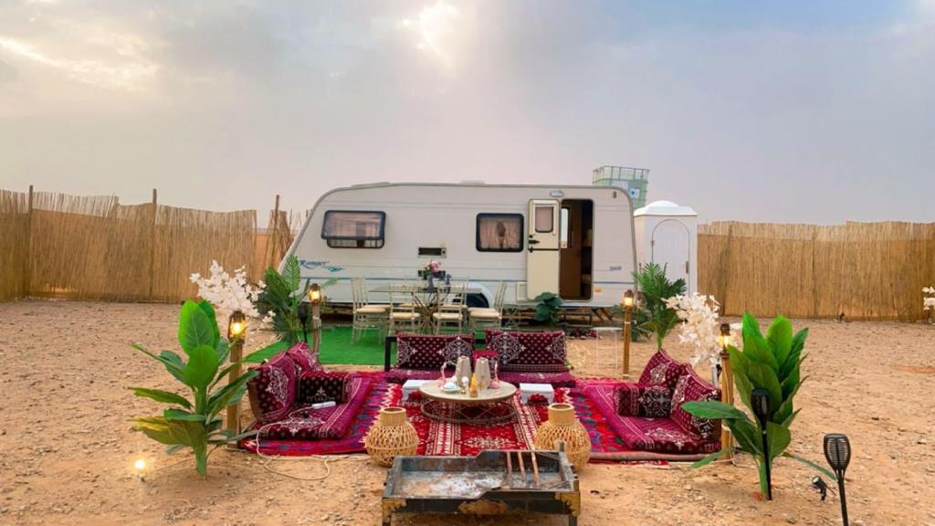 RV zaparkowany na dziedzińcu ze stołem i krzesłami w obiekcie كرفان قمر الليل الملكي مع ضيافة vip w Rijadzie