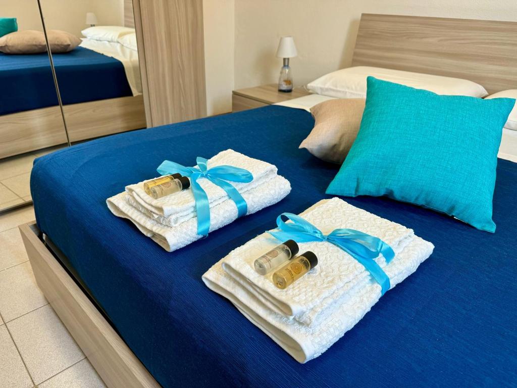 a bed with towels and bottles of wine on it at Il Quarzo Azzurro in Càbras