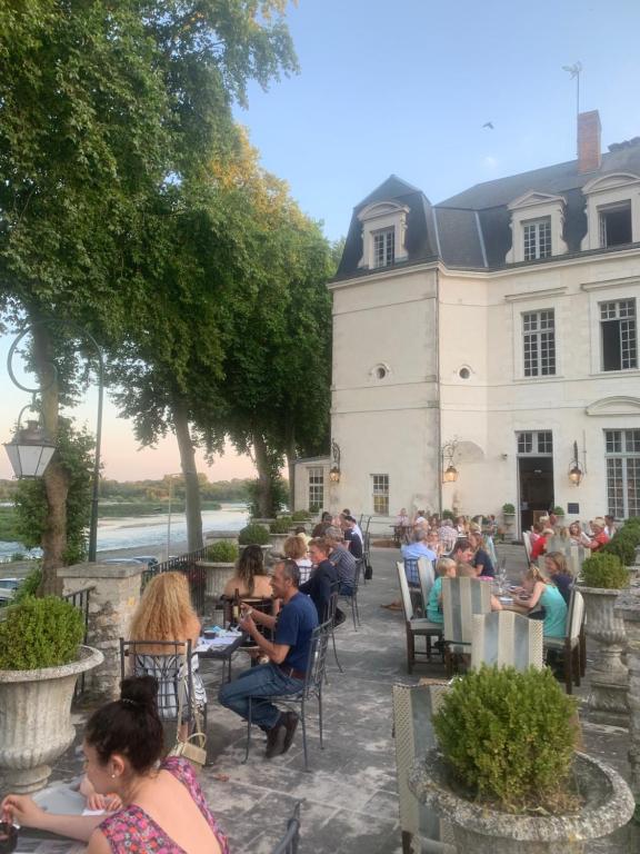 a group of people sitting at tables in front of a building at Grand Hôtel de l'Abbaye in Beaugency