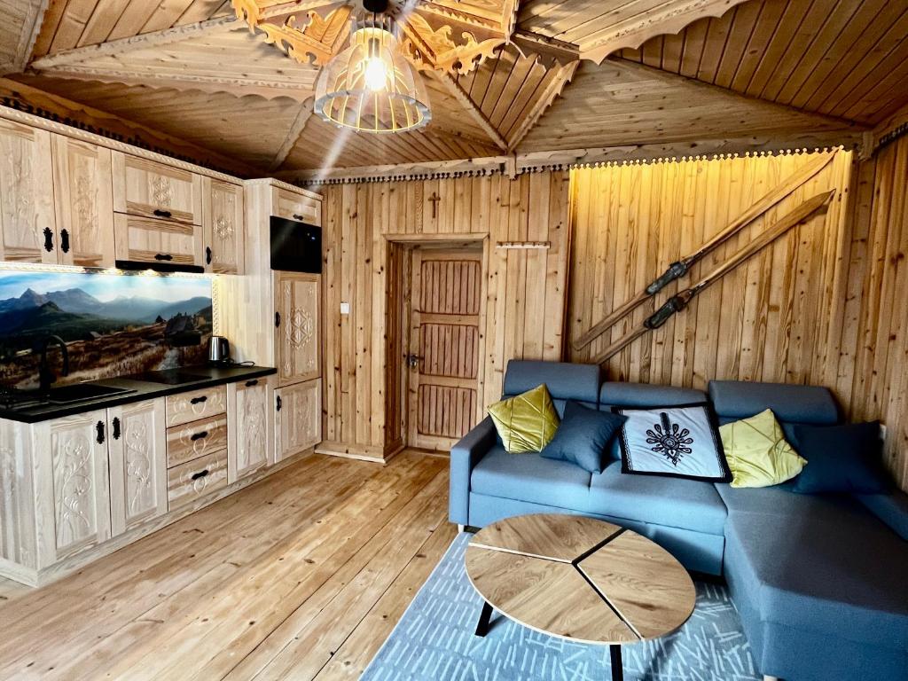 a living room with a blue couch and a table at Apartamenty Smrekowka in Zakopane