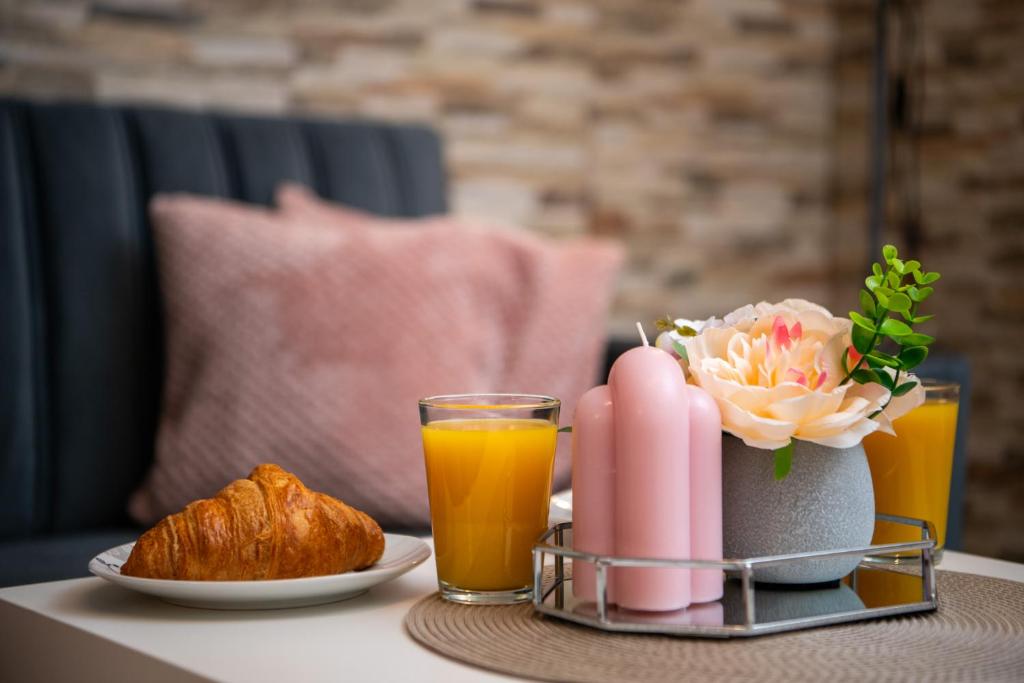 a table with a tray of breakfast foods and orange juice at Apartman u srcu antičke Pule in Pula