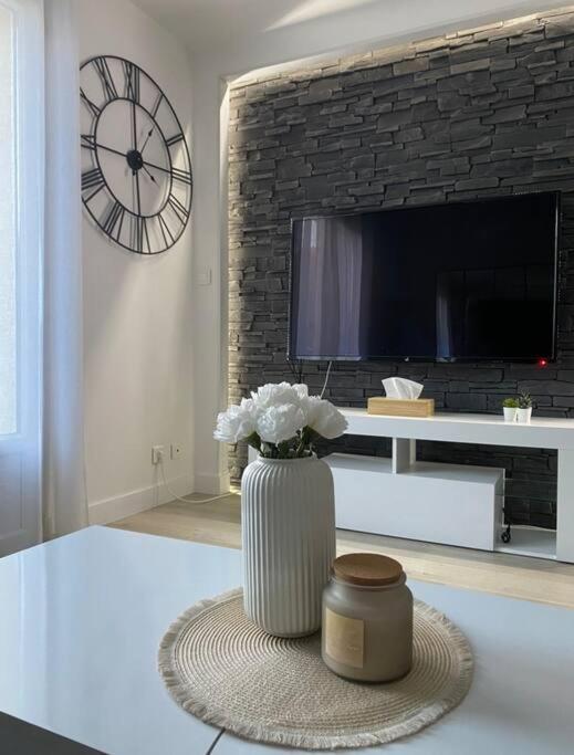 a vase with flowers on a table in a living room at Le Cottage Apaisant in Ardon