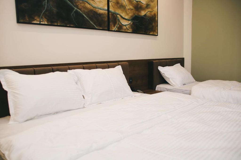 a bedroom with two beds with white pillows at Hotel Rozafa in Suharekë