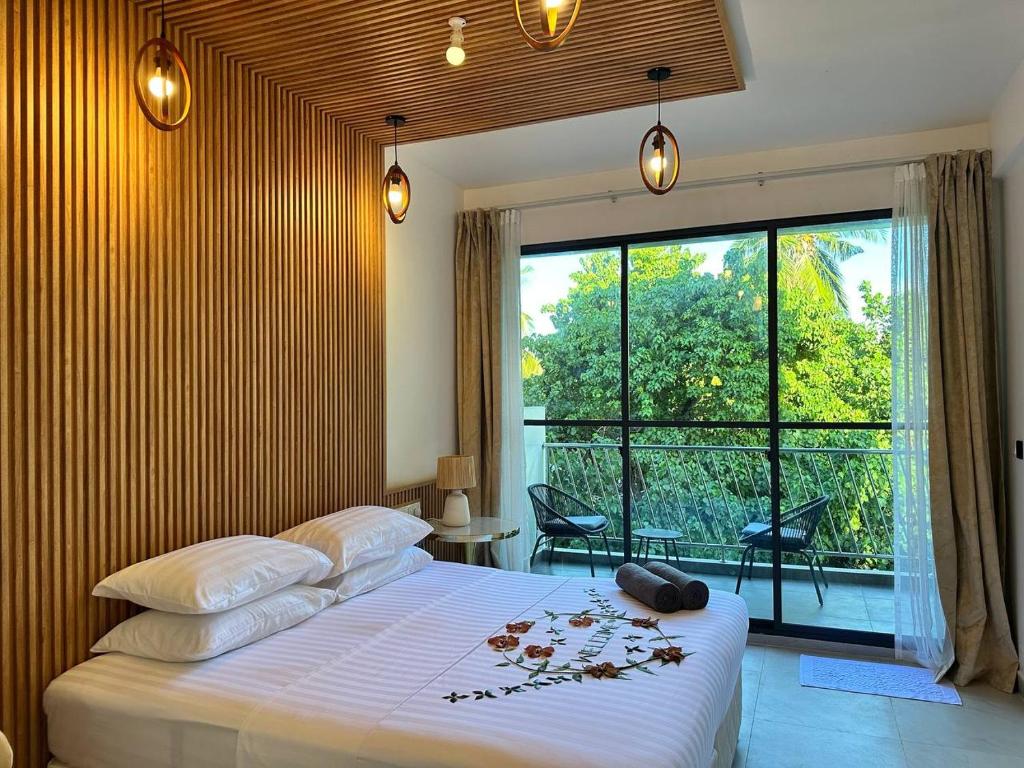 a bedroom with a large bed and a large window at Serene Sky Guest house in Thoddoo