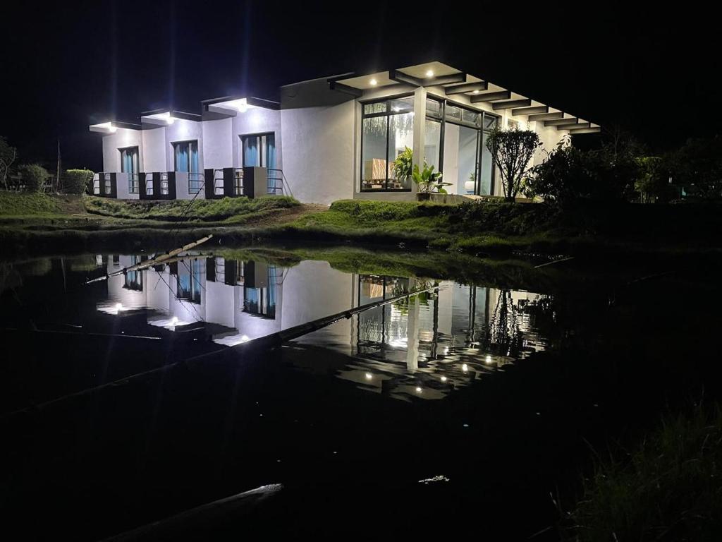 een huis 's nachts met een reflectie in het water bij Dream's Hôtel in Antsirabe