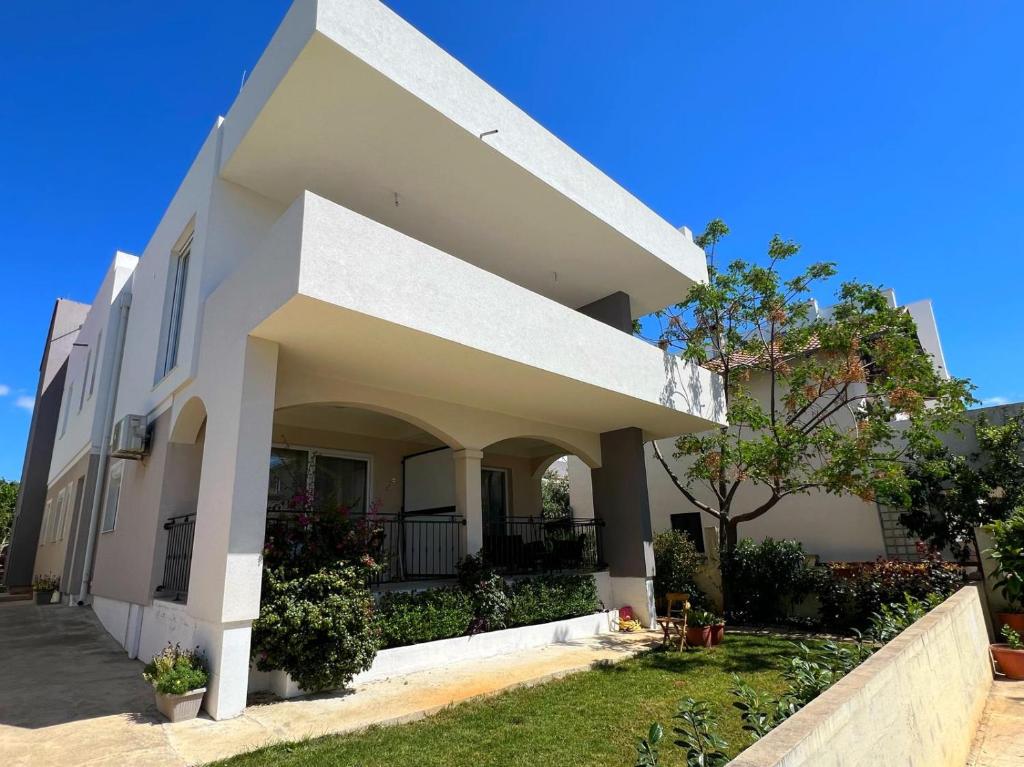 una grande casa bianca con un albero di fronte di Sea Dream Apartments a Bibinje (Bibigne)