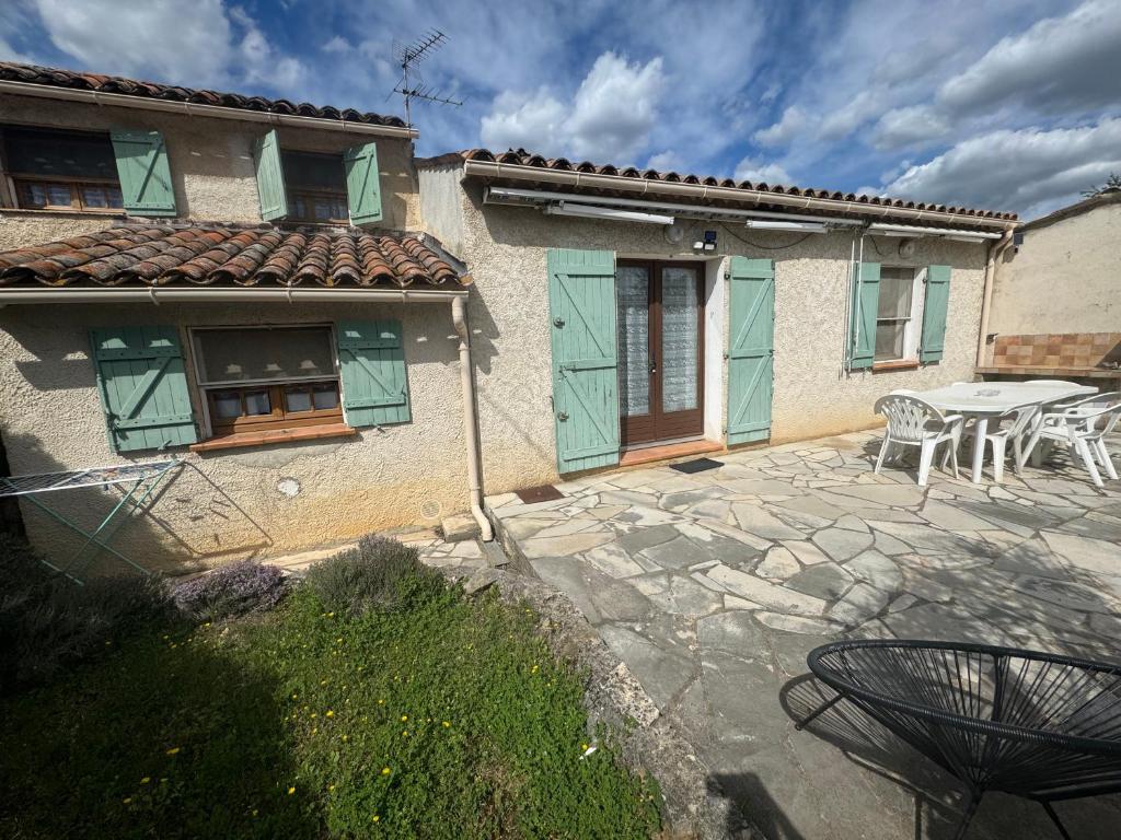 a house with a patio with a table and chairs at La maison des Passereaux in Callian