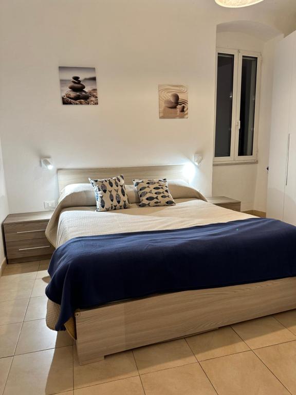 1 dormitorio con 1 cama grande con sábanas y almohadas azules en Central Seaview Apartment en Lerici