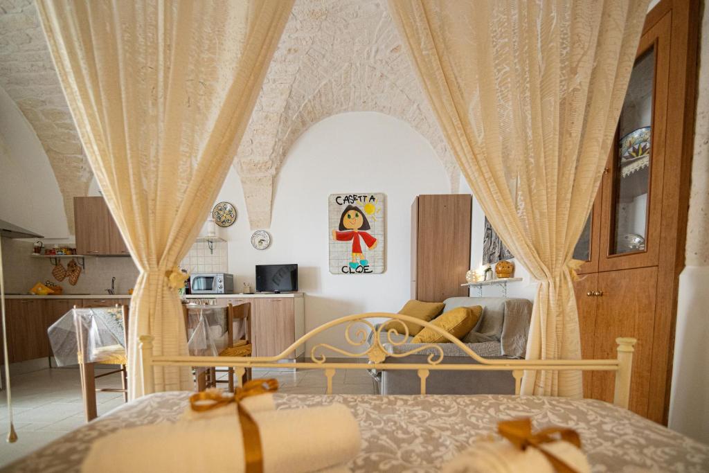 una camera da letto con letto, tende e divano di CASETTA CLOE house of charm and romance a Ceglie Messapica