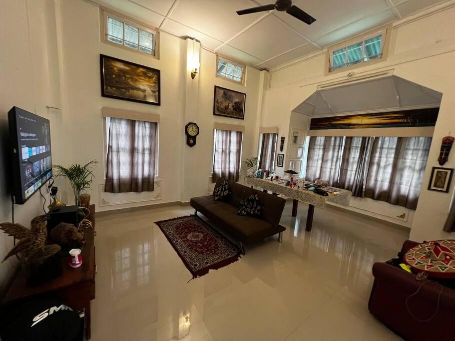 a large living room with a couch and a tv at Palm715 Villa in jorhat in Jorhāt