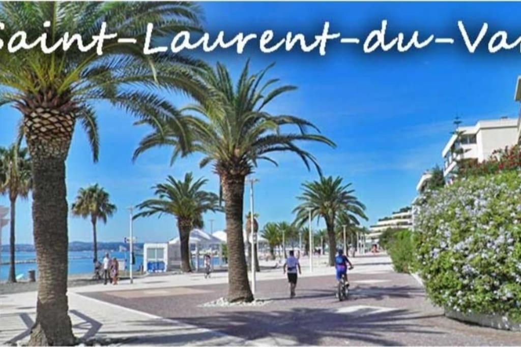 une personne à vélo dans une rue bordée de palmiers dans l'établissement Studio in villa with parking and private garden, à Saint-Laurent-du-Var