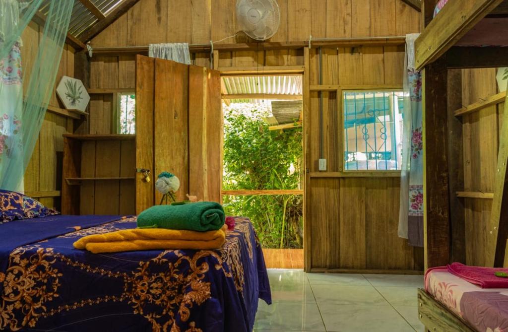 Los Paniquines Ecolodge في دريك: غرفة نوم بسرير وبطانية زرقاء ونافذة