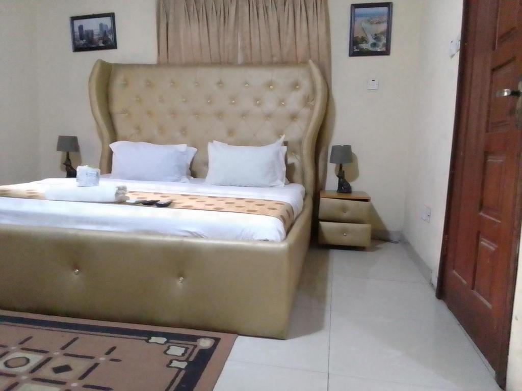 a bedroom with a large bed with a large headboard at Light house hotel Lekki phase 1 in Lekki