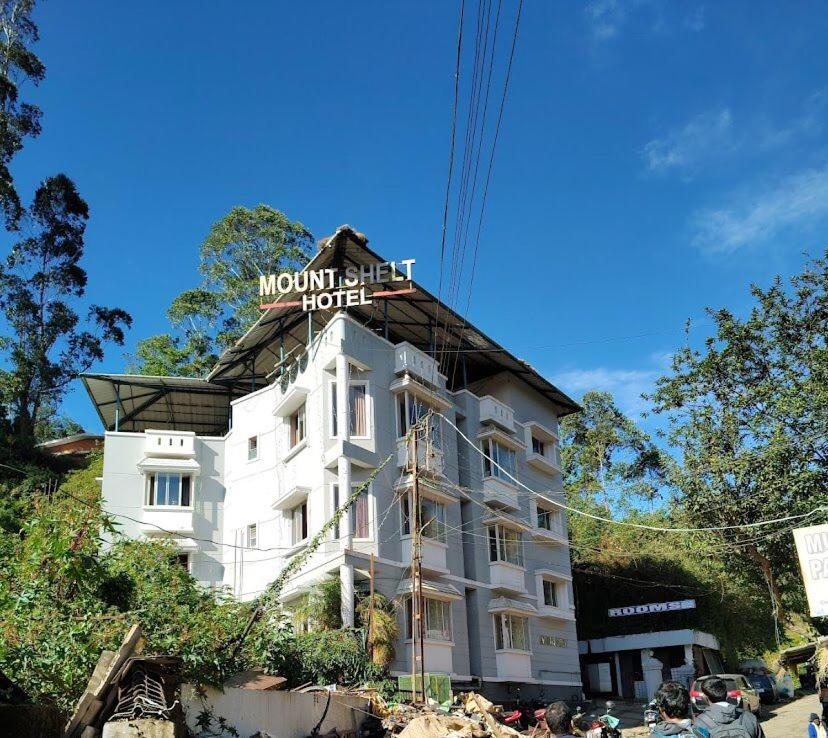 蒙納的住宿－Munnar Mount Shelt Hotel，上面有标志的建筑