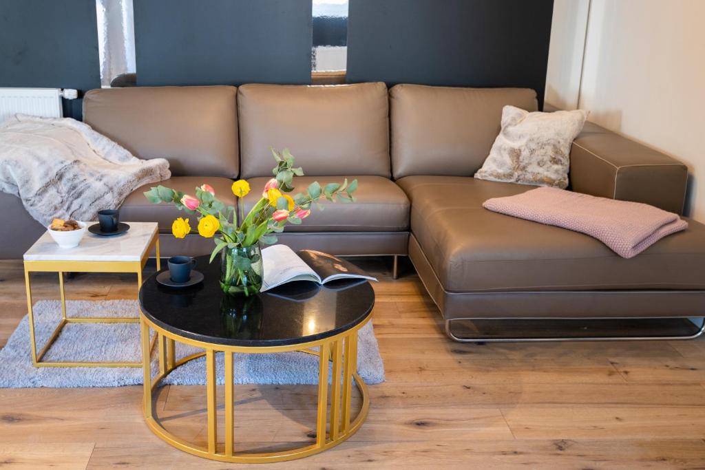 uma sala de estar com um sofá e uma mesa com flores em Sope Skylodge 03 - Elvin's Hüsle - Oberried, Schauinsland em Oberried