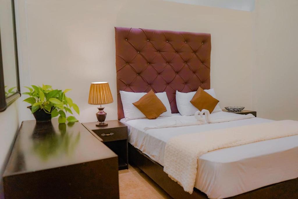 a bedroom with a large bed with a large headboard at The Lamendriea Hotel in Kalagedihena