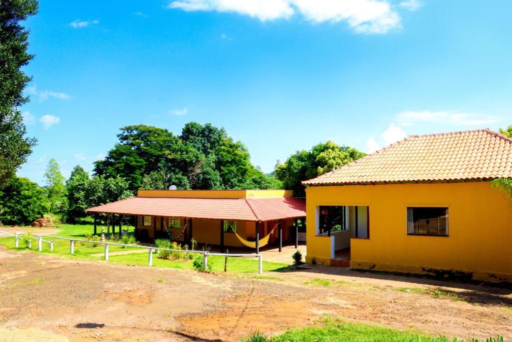 a small yellow house with a red roof at Pousada - Pesqueiro do Brasinha in Itamogi