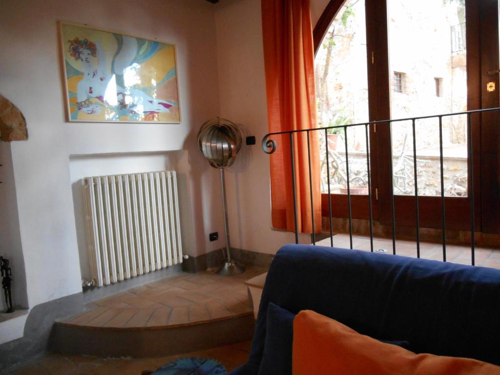 salon z niebieską kanapą i oknem w obiekcie Podere Sammonti w mieście Monteriggioni