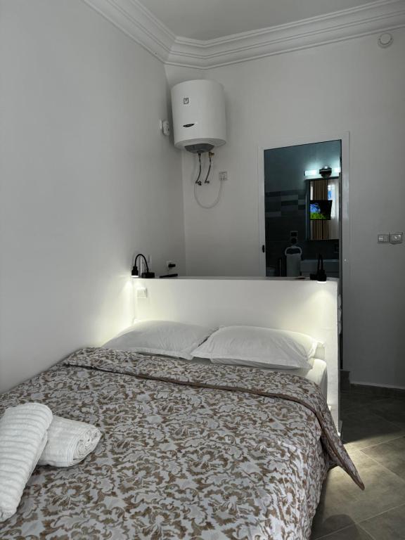 a white bedroom with a large bed with two pillows at SIMI home in Essaouira