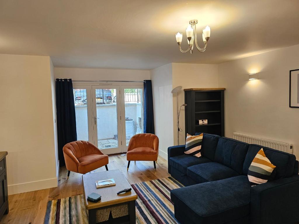 a living room with a blue couch and a chair at Spacious, modern 2-bedroom flat in Clifton in Bristol