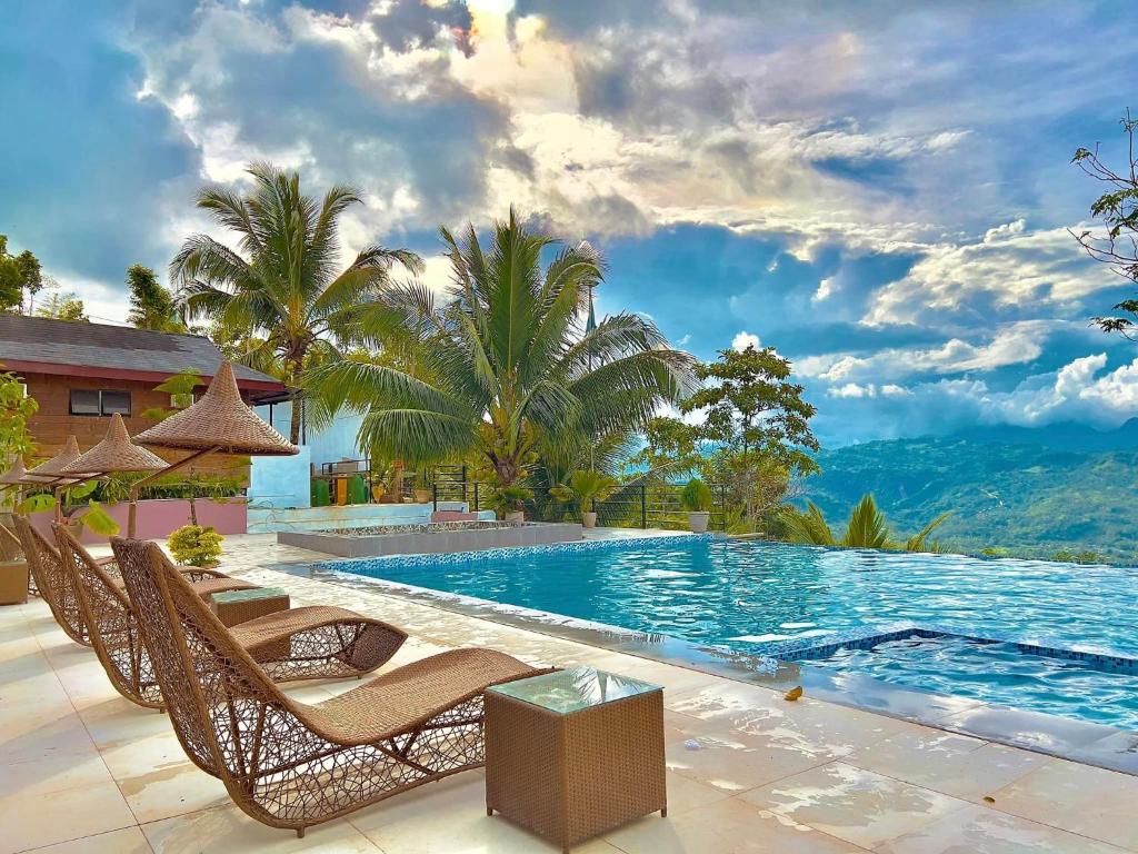 een zwembad met stoelen en bomen en een berg bij Mabini Sky View Resort in Cebu City