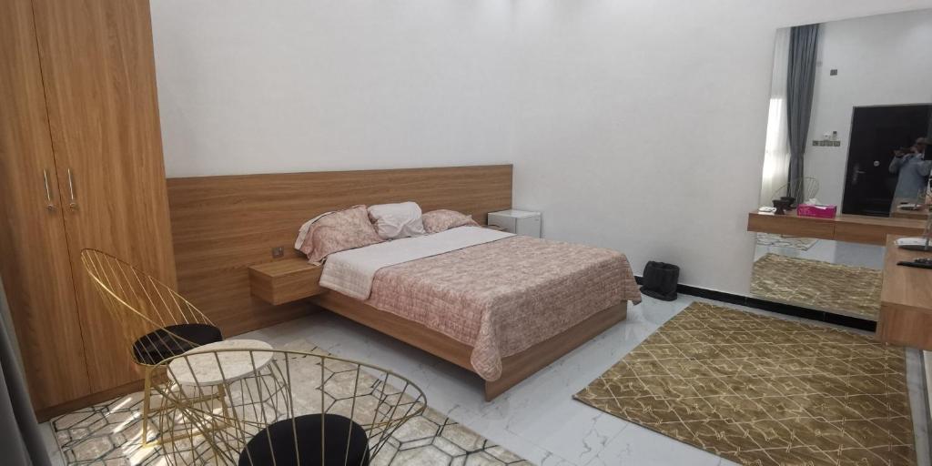 1 dormitorio con 1 cama y 2 sillas en نزوي, en Nizwa